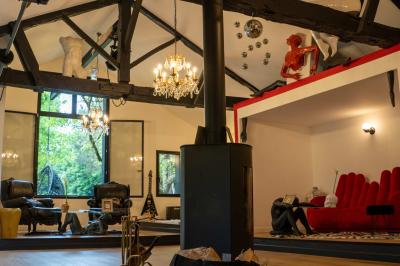 Salle de bain avec un grand miroir doré, deux vasques noires, robinetterie dorée et décoration moderne.