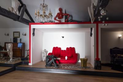 Salle de bain avec un grand miroir doré, deux vasques noires, robinetterie dorée et décoration moderne.