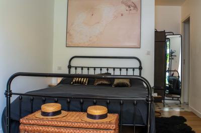 Salle de bain avec un grand miroir doré, deux vasques noires, robinetterie dorée et décoration moderne.