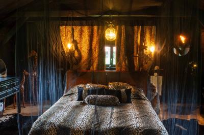Salle de bain avec un grand miroir doré, deux vasques noires, robinetterie dorée et décoration moderne.