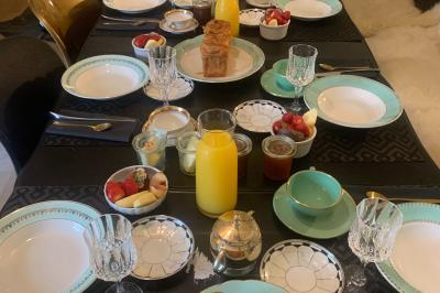 Salle de bain avec un grand miroir doré, deux vasques noires, robinetterie dorée et décoration moderne.