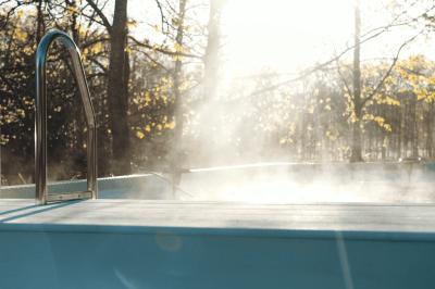 Salle de bain avec un grand miroir doré, deux vasques noires, robinetterie dorée et décoration moderne.
