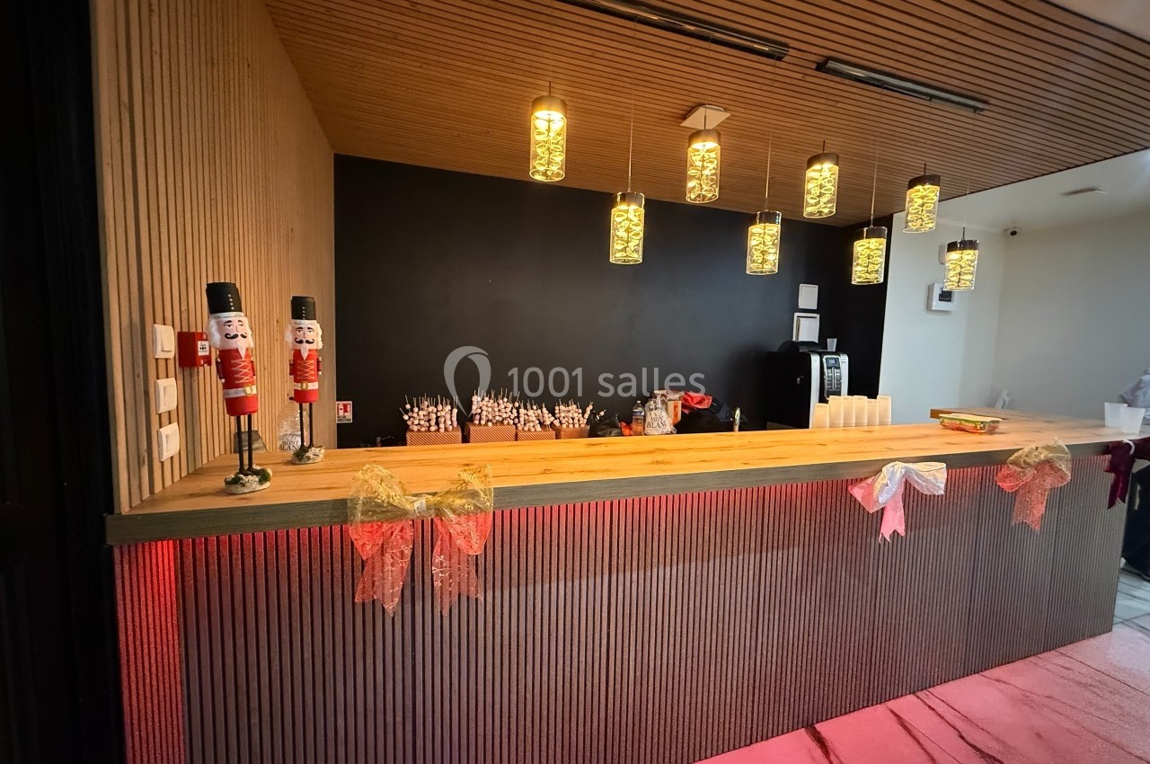 Comptoir en bois décoré de rubans et figurines, éclairé par des suspensions, avec des verres et une machine à café en…