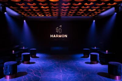 Couloir avec parquet en bois sombre, éclairé par des panneaux lumineux aux motifs géométriques.