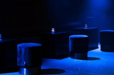 Couloir avec parquet en bois sombre, éclairé par des panneaux lumineux aux motifs géométriques.