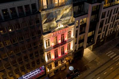 Couloir avec parquet en bois sombre, éclairé par des panneaux lumineux aux motifs géométriques.