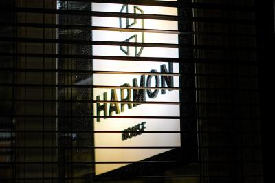 Couloir avec parquet en bois sombre, éclairé par des panneaux lumineux aux motifs géométriques.