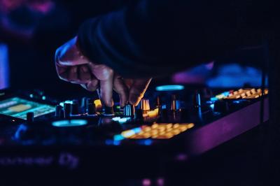 Miniature Location salle Bruxelles (Bruxelles-Capitale) - Harmon House #14 Main ajustant des commandes sur une table de mixage éclairée dans une ambiance sombre et lumineuse.