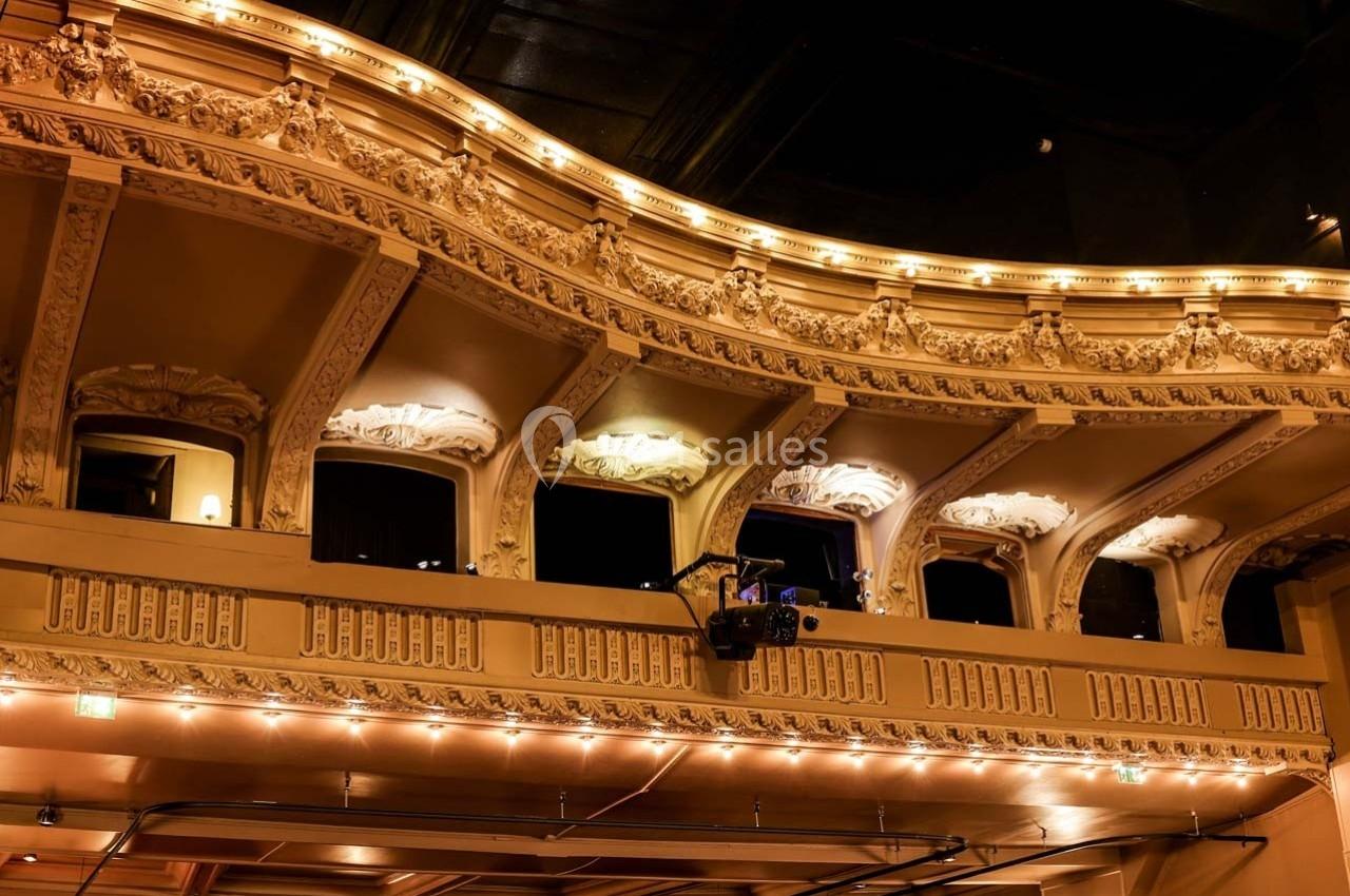 Balcon de la Grande salle du Palais des Glaces Balcon d'un théâtre avec des ornements détaillés, éclairé par des lumières chaudes dans une ambiance nocturne.