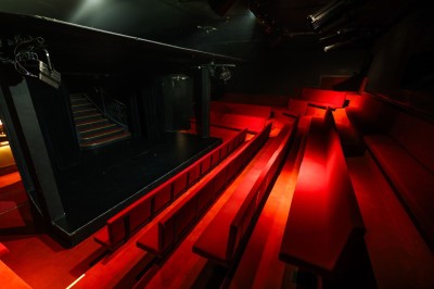 Miniature Petit Palais des Glaces Salle avec moquette rouge, table en bois clair, chaises rouges et miroir éclairé par des ampoules.