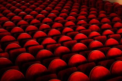 Miniature Sièges de la Grande salle du Palais des Glaces Salle avec moquette rouge, table en bois clair, chaises rouges et miroir éclairé par des ampoules.