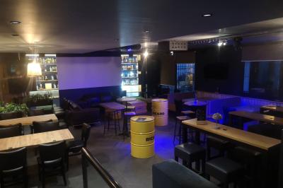 Deux micros sur pied dans une salle sombre, éclairée par un écran lumineux affichant un texte flou.