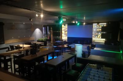 Deux micros sur pied dans une salle sombre, éclairée par un écran lumineux affichant un texte flou.