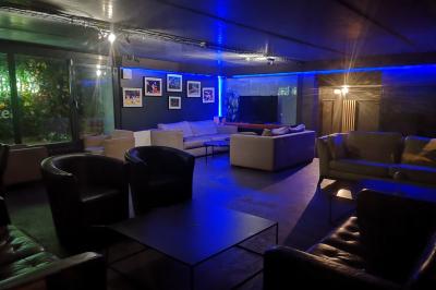 Deux micros sur pied dans une salle sombre, éclairée par un écran lumineux affichant un texte flou.