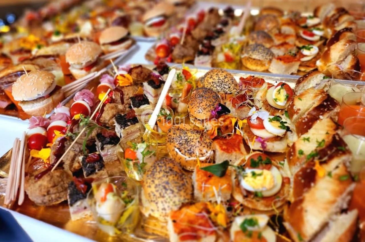 Plateau de canapés variés avec pains, légumes, viandes, poissons et garnitures colorées, disposés pour un buffet.