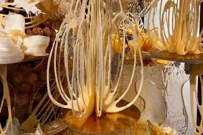 Deux faisceaux lumineux blancs traversent une salle sombre avec des murs en pierre apparente.