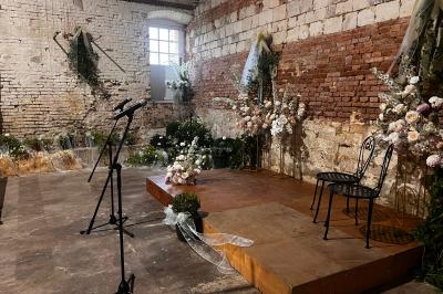 Deux faisceaux lumineux blancs traversent une salle sombre avec des murs en pierre apparente.