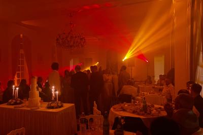 Deux faisceaux lumineux blancs traversent une salle sombre avec des murs en pierre apparente.