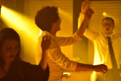 Deux faisceaux lumineux blancs traversent une salle avec des murs en pierre, éclairant un espace légèrement enfumé.