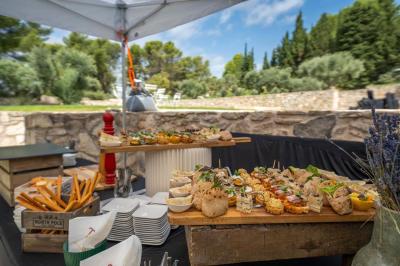 Salon avec canapé beige, fauteuils, table basse, télévision, cheminée en pierre et plafond avec poutres apparentes.