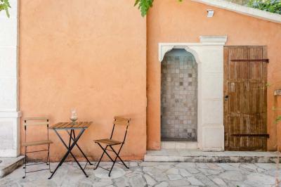 Salon avec canapé beige, fauteuils, table basse, télévision, cheminée en pierre et plafond avec poutres apparentes.