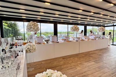 Miniature La Verrière Salle de réception décorée avec des fleurs blanches, des tables élégantes et un éclairage rose tamisé.