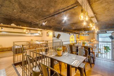 Miniature Location salle Lille (Nord) - Marta Bar Restaurant #4 Préparation d'une pizza avec des mains ajoutant des tranches de chorizo sur une pâte garnie de sauce tomate et fromage râpé.