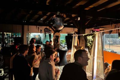 Miniature Location salle Le Bouscat (Gironde) - Côté Court #16 Entrée d'un café avec une grande terrasse, un parasol orange et des meubles en osier sous un ciel bleu.