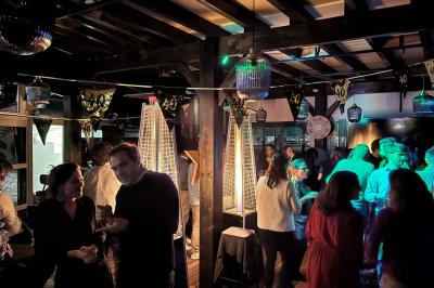 Miniature Location salle Le Bouscat (Gironde) - Côté Court #19 Entrée d'un café avec une grande terrasse, un parasol orange et des meubles en osier sous un ciel bleu.