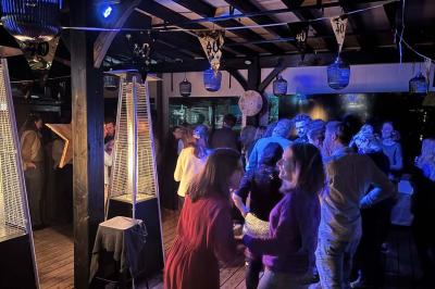 Miniature Location salle Le Bouscat (Gironde) - Côté Court #20 Entrée d'un café avec une grande terrasse, un parasol orange et des meubles en osier sous un ciel bleu.