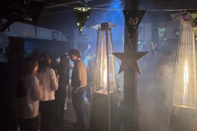 Miniature Location salle Le Bouscat (Gironde) - Côté Court #8 Entrée d'un café avec une grande terrasse, un parasol orange et des meubles en osier sous un ciel bleu.