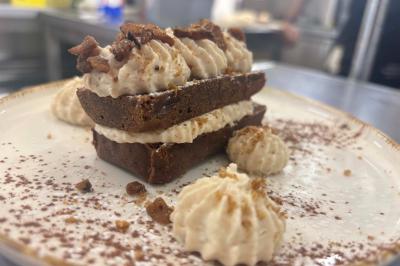 Miniature Location salle Le Bouscat (Gironde) - Côté Court #31 Entrée d'un café avec une grande terrasse, un parasol orange et des meubles en osier sous un ciel bleu.