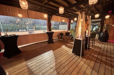 Miniature Location salle Le Bouscat (Gironde) - Côté Court #5 Entrée d'un café avec une grande terrasse, un parasol orange et des meubles en osier sous un ciel bleu.