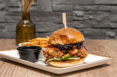 Miniature Location salle Le Bouscat (Gironde) - Côté Court #28 Entrée d'un café avec une grande terrasse, un parasol orange et des meubles en osier sous un ciel bleu.