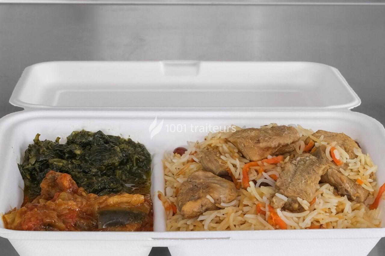 Plat à emporter dans une boîte en polystyrène contenant du riz avec morceaux de viande, légumes en sauce et épinards.