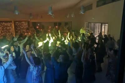 Deux enceintes sur trépieds et un caisson de basses posés sur un sol pavé devant une porte de garage.