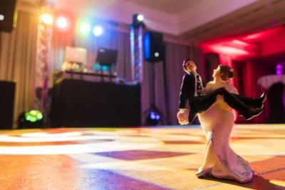 Deux enceintes sur trépieds et un caisson de basses posés sur un sol pavé devant une porte de garage.