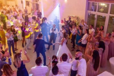 Deux enceintes sur trépieds et un caisson de basses posés sur un sol pavé devant une porte de garage.