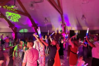 Deux enceintes sur trépieds et un caisson de basses posés sur un sol pavé devant une porte de garage.