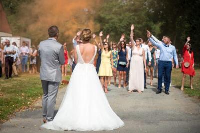 Deux enceintes sur trépieds et un caisson de basses posés sur un sol pavé devant une porte de garage.