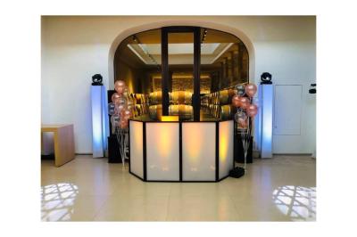 Deux enceintes sur trépieds et un caisson de basses posés sur un sol pavé devant une porte de garage.