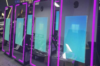 Deux personnes déguisées posent devant un smartphone affichant leur photo, accompagnées de deux autres en arrière-plan.