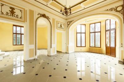 Centre de table floral avec roses roses, fleurs violettes et blanches, entouré de bougies et de verres sur une nappe blanche.