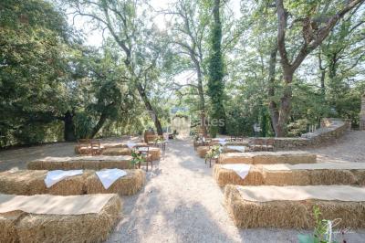 Miniature Location salle Signes (Var) - Château de Cancerilles #18 Mobilier de jardin blanc disposé sur une terrasse en gravier, avec vue sur des vignes et une forêt en arrière-plan.