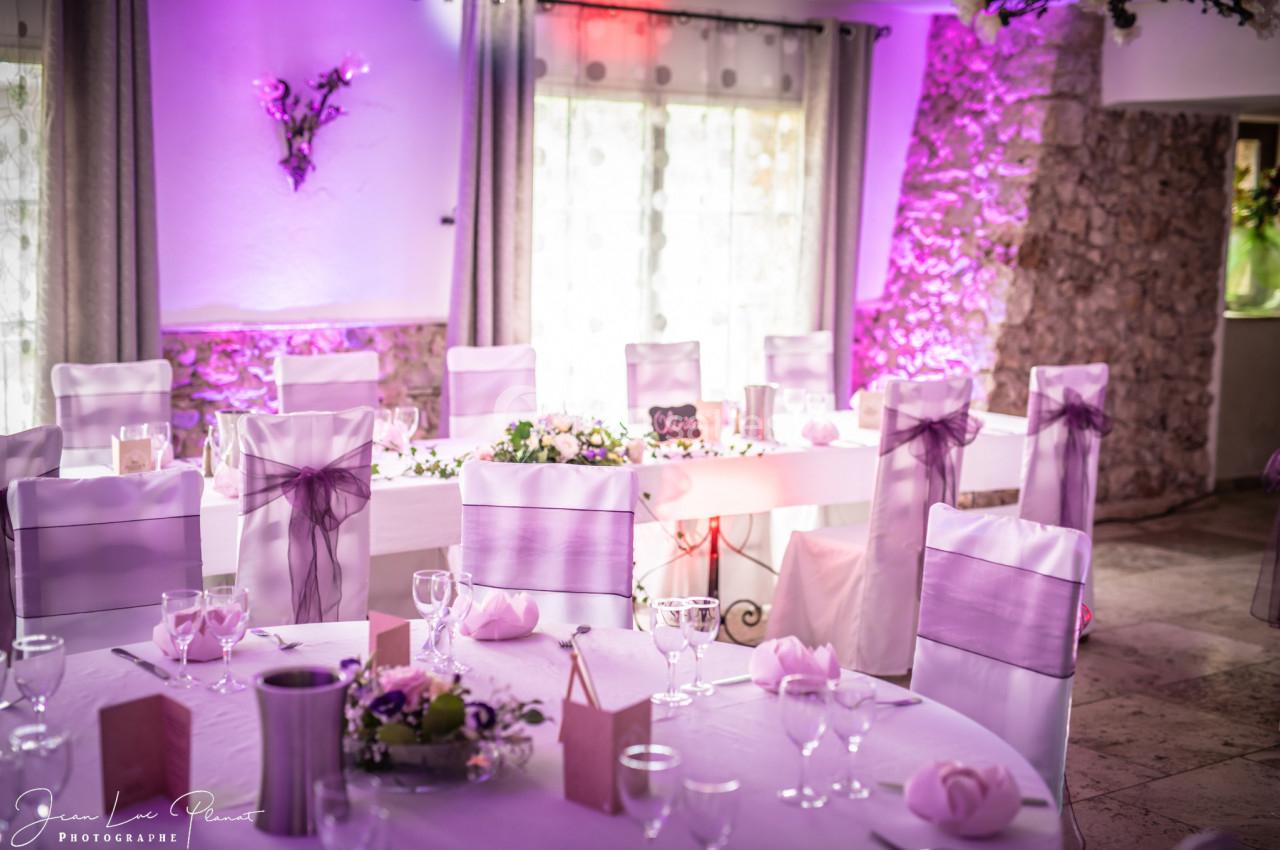 Location salle Signes (Var) - Château de Cancerilles #23 Salle de réception décorée pour un événement, avec des tables dressées et des chaises ornées de nœuds violets.
