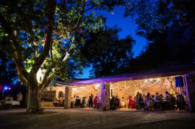 Miniature Location salle Signes (Var) - Château de Cancerilles #4 Mobilier de jardin blanc disposé sur une terrasse en gravier, avec vue sur des vignes et une forêt en arrière-plan.