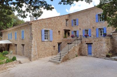 Miniature Location salle Signes (Var) - Château de Cancerilles #3 Mobilier de jardin blanc disposé sur une terrasse en gravier, avec vue sur des vignes et une forêt en arrière-plan.