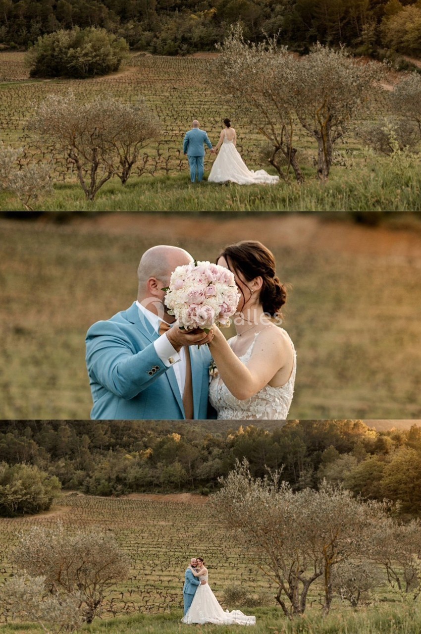Location salle Signes (Var) - Château de Cancerilles #50 Un couple en tenue de mariage dans un paysage champêtre, entouré de vignes et d'arbres, tenant un bouquet de fleurs.