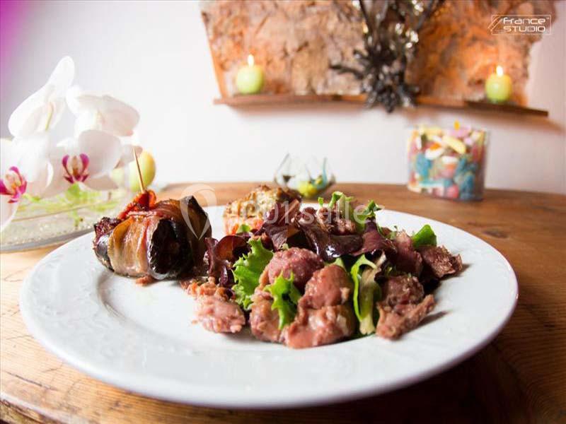 Location salle Signes (Var) - Château de Cancerilles #32 Assiette garnie de salade, viande et accompagnements, présentée sur une table en bois avec une décoration en arrière-plan.