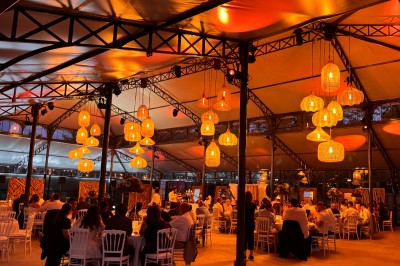 Miniature Location salle Rosny-sur-Seine (Yvelines) - L'Orangerie de L'Orée du Bois #1 Salle de réception illuminée par des suspensions lumineuses, avec des invités assis à des tables rondes.
